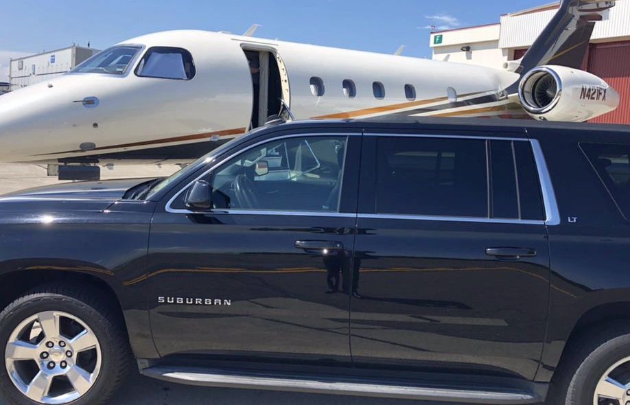 Black Suburban and private jet